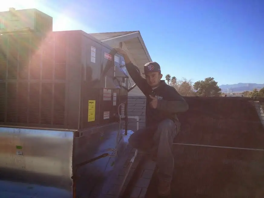 HVAC technician performing AC Tune-Up on a rooftop unit in King City